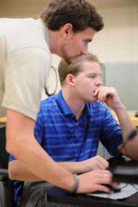 Student researchers discussing results at a PC workstation